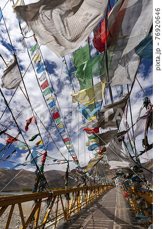 Prayer flags on a footbridge - Tibet 76920646
