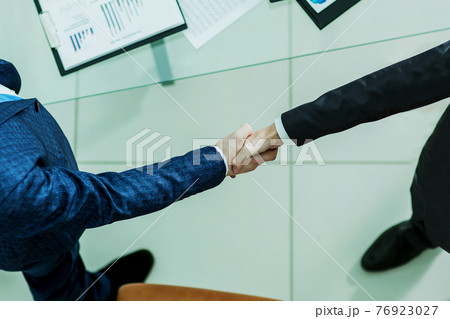 handshake financial partners, on the desktop background, with the financial schedules 76923027