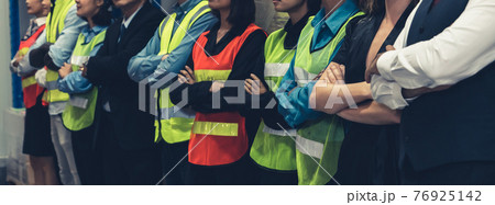 Large group of factory worker standing together in warehouse or storehouse 76925142