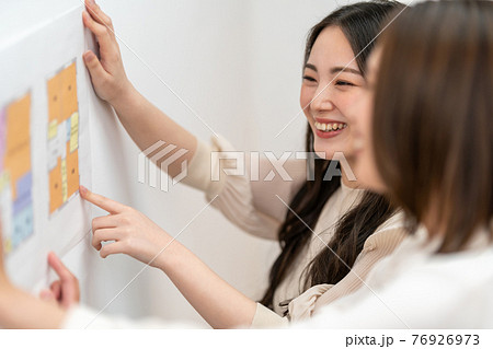 住宅の間取り図面を見ながら打ち合わせをする女性二人　ビジネスシーン 76926973