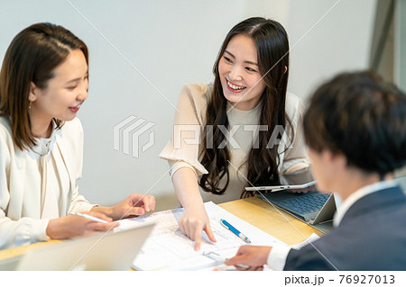 住宅の間取り図面を見ながら打ち合わせをする男女三人 建築士　ビジネスシーン 76927013