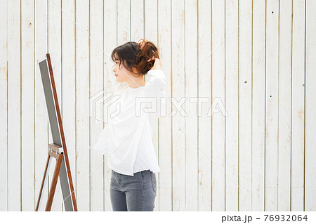 ヘアスタイルのセットをする若い女性 76932064