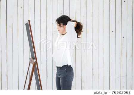 ヘアスタイルのセットをする若い女性 76932068