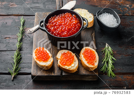 Canape toast with red caviar, on old dark wooden table background Canape toast with red caviar, on old dark wooden table background 76932583
