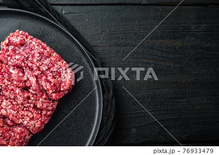Minced meat, on black wooden table background, top view flat lay with copy space for text Minced meat, on black wooden table background, top view flat lay with copy space for text 76933479