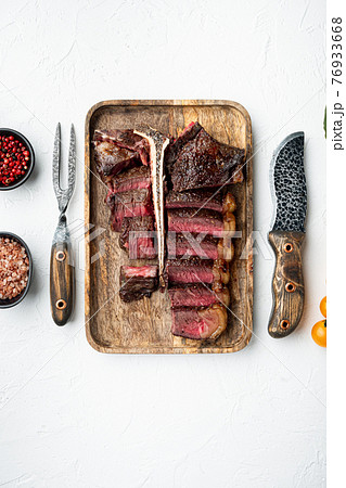 Fresh juicy medium rare Sliced and roast T bone or porterhouse beef meat Steak, on white stone background, top view flat lay, with copy space for text 76933668