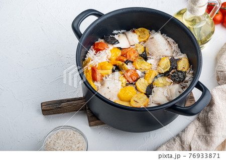 One pan fabulous fish with basmati rice and cherry tomatoes, on white background with copy space for text 76933871