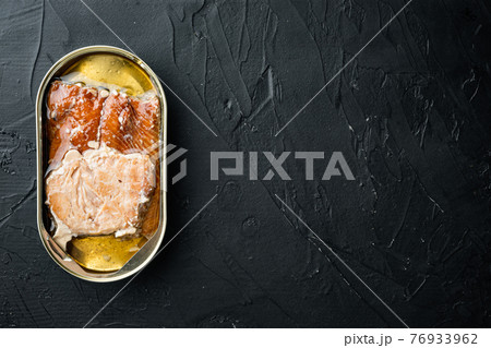 Wild Pink Salmon Canned smoked fish, in tin can, on black background, top view flat lay, with copyspace and space for text 76933962