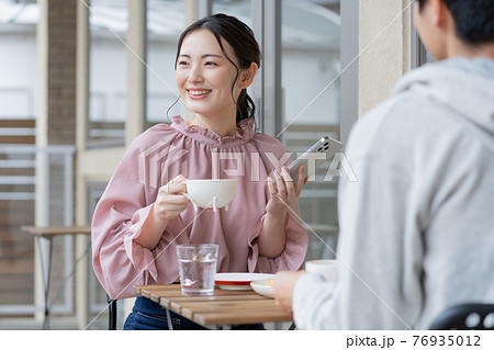 カフェで談笑する若いカップル カフェで談笑する若いカップル 76935012