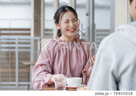 カフェで談笑する若いカップル カフェで談笑する若いカップル 76935018