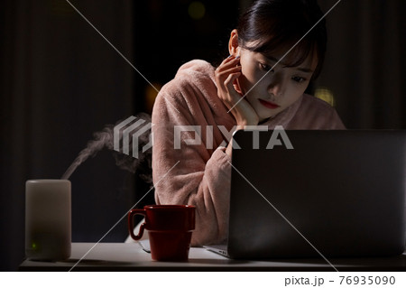深夜に自宅で仕事をする若い女性 深夜に自宅で仕事をする若い女性 76935090