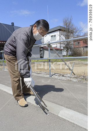 ゴミ拾いをするシニア男性 76936619