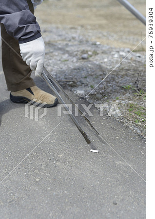 吸い殻を拾うシニア男性（顔なし） 76939304