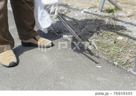 吸い殻を拾うシニア男性（顔なし） 76939305