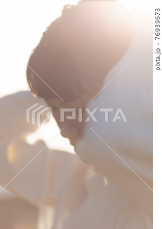 長い髪をまとめる女性 長い髪をまとめる女性 76939673