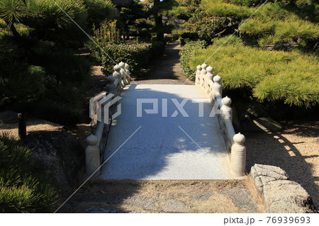 公園内の石の橋に木の影が覆っている 76939693