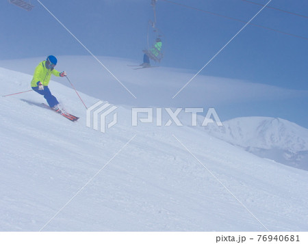 白馬八方尾根スキー場　兎平ゲレンデ　薄霧の中を滑るスキーヤー 76940681