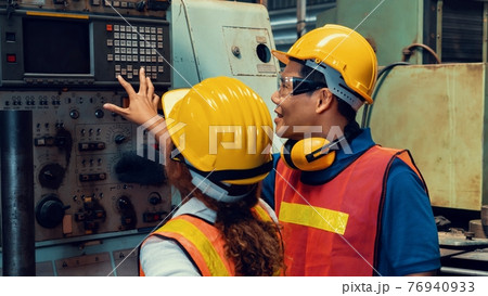 Group of skillful workers using machine equipment in factory workshop 76940933