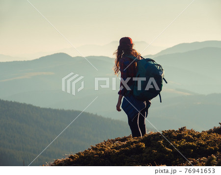 Hiker Woman with Backpack on Top of a Mountain Hiker Woman with Backpack on Top of a Mountain 76941653