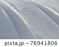 Traces from the car on a snowy road. 76941806