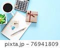 Business, finance, savings, money management, property loan or mortgage concept : Top view or flat lay of wood house model on open notebook paper, calculator, coffee and gift box on office desk table 76941809