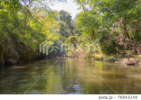 Sailing on lake or river water rafting, paddling on boat canal in park. Sightseeing in forest trees at Mae Sot ,Tak, Thailand. Nature landscape. Tourist adventure activity. Travel in holiday vacation. 76943249