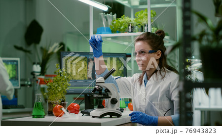 Biologist scientist looking at test sample using microscope Biologist scientist looking at test sample using microscope 76943823