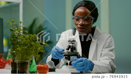 Portrait of pharmaceutical woman putting slide under microscope Portrait of pharmaceutical woman putting slide under microscope 76943915