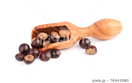 Guarana seed in wooden scoop, isolated on white background. Dietary supplement guarana, caffeine cource for energy drinks. 76943980
