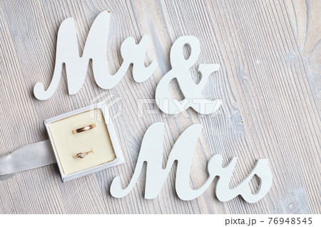 Wedding rings in a box next to the inscriptions Mr and Mrs on a wooden background. Wedding rings in a box next to the inscriptions Mr and Mrs on a wooden background. 76948545