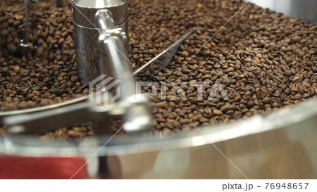Close view of mixing and grinding roasted coffee beans with equipment 76948657