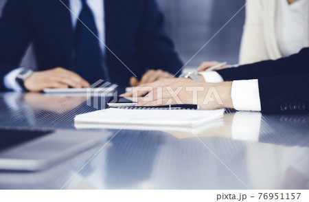 Business people working together at meeting in a modern office. Unknown businessman and woman with colleagues or lawyers at negotiation about contract 76951157