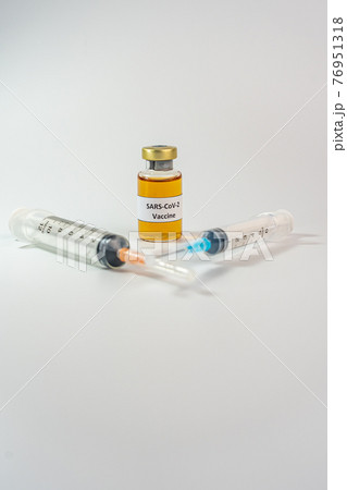 Sars-CoV-2 vaccine bottle and syringes on white background 76951318