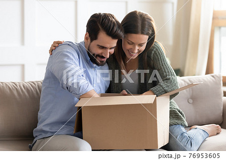 Happy couple unpack box with internet order 76953605