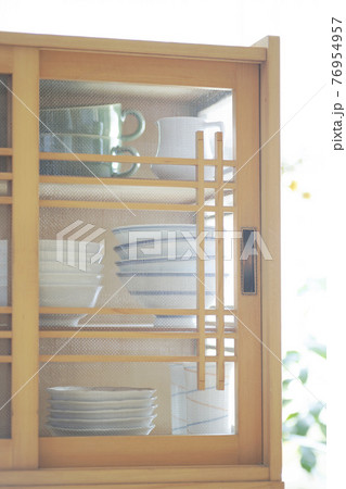 朝日の差し込む部屋、和食器が収納された食器棚 76954957