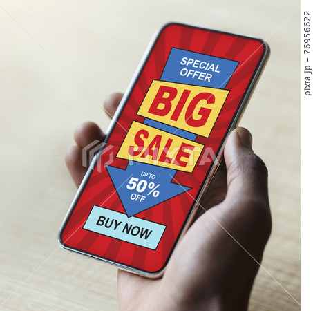 Black guy hand with big sale advertisement on smartphone 76956622
