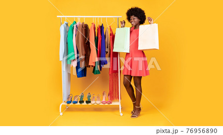 Happy Black Shopaholic Woman Showing Shopper Bags, Yellow Background, Panorama 76956890