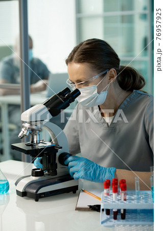 Virologist learning cells under microscope Virologist learning cells under microscope 76957925