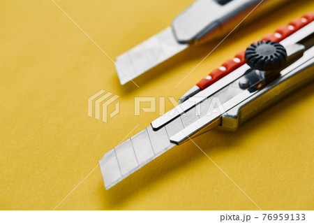Razor, construction knife, yellow background 76959133