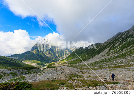 剱の雄大な山々と登山道を進む人 76959809