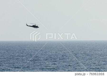helicopter flying over blue sea 76961008
