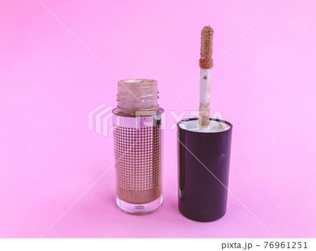Beautiful fashionable beauty cosmetic glamorous red liquid matte lipstick in a tube with a sponge for applying texture to apply makeup on the lips on a pink delicate background 76961251