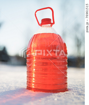 bottle with non-freezing windshield washer fluid, snow background 76961515