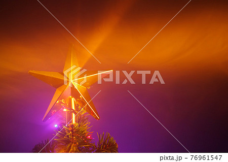Christmas tree shiny star, purple background with smoke Christmas tree shiny star, purple background with smoke 76961547