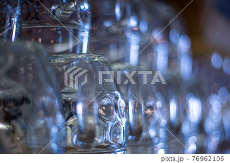 Blurred background of glass beer mugs in pub. Beer backdrop, brewing traditions 76962106
