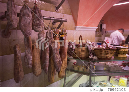 Jamon and Traditional Spanish sausages and meats on wall and counter of old shop 76962108