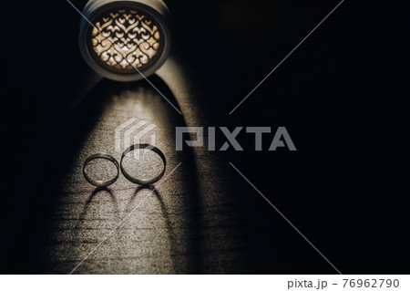 Close-up of two gold wedding rings on a black background Close-up of two gold wedding rings on a black background 76962790