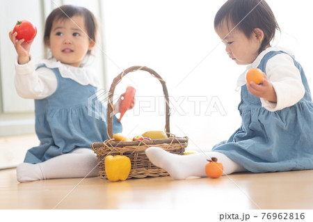 部屋で遊ぶかわいい双子の幼児の写真素材