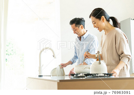 キッチンで料理をするミドルカップル 76963091