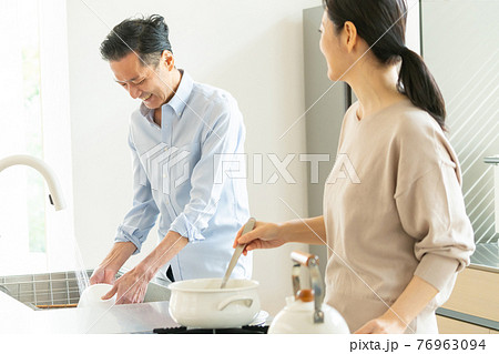 キッチンで料理をするミドルカップル 76963094